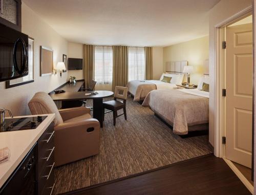 a hotel room with two beds and a desk at Candlewood Suites Beaumont, an IHG Hotel in Beaumont