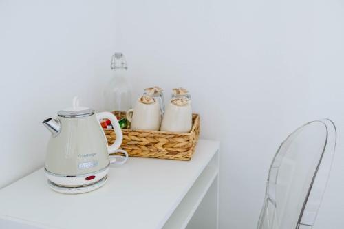 a white kitchen with two tea pots on a counter at ABC affittacamere in Celle Ligure