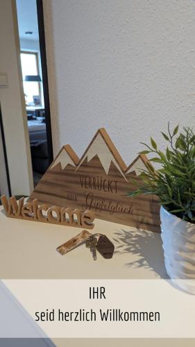 a wooden sign with a mountain on a table at Ferienwohnung Bergzeit mit Pool und Sauna in Missen-Wilhams