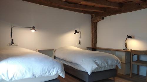 2 camas en una habitación con luces en la pared en Venta de Arrieta, en Saragüeta