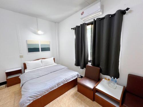 Habitación pequeña con cama y ventana en Tokyo Hotel, en Nakhon Ratchasima