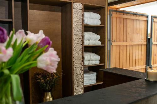 La salle de bains est pourvue de serviettes et d'une table avec des fleurs. dans l'établissement Golden Golem hotel & Spa, à Prague