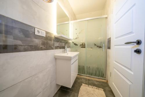 a white bathroom with a sink and a shower at Terra Ares in Kayakoy