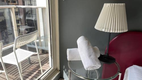 a room with a lamp and a chair and a window at Ausmine Sydney CBD 2Bedroom Apt in Sydney