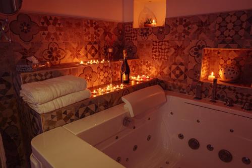 a bathroom with a tub with candles and lights at La Terrazza Sulla Rupe Relais in Ostuni