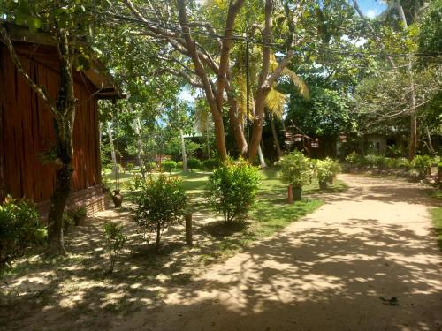 a garden with trees and a dirt road at Lake Resort Bolgoda in Wadduwa