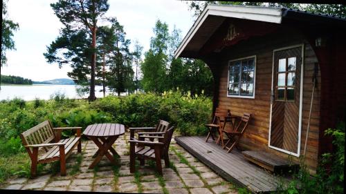 a cabin with a table and chairs on a deck at Mysigt boende på Brenäsudden in Insjön