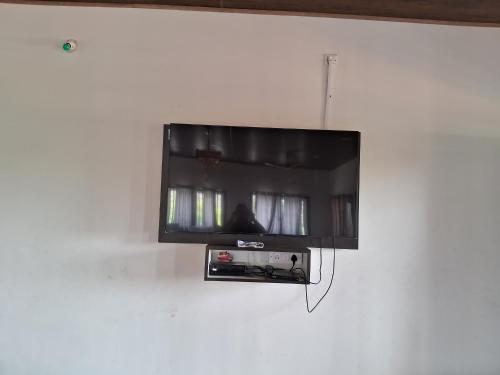 a flat screen tv hanging on a wall at Royal homes a3 in Kushālnagar