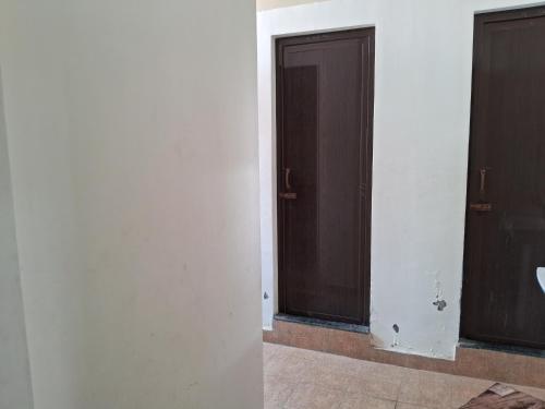 two doors in a room with white walls at Royal homes a3 in Kushālnagar