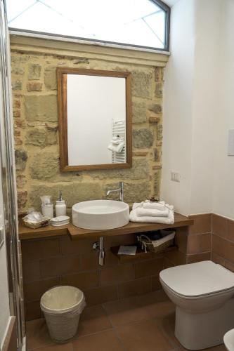 a bathroom with a sink and a toilet and a mirror at La Casa del Fabbro in Troina