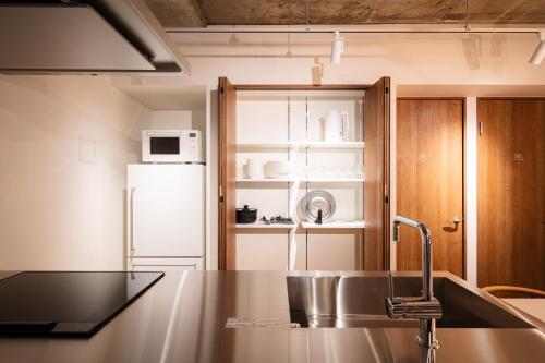 a kitchen with a sink and a refrigerator at MANGA ART HOTEL, BAKUROCHO in Tokyo