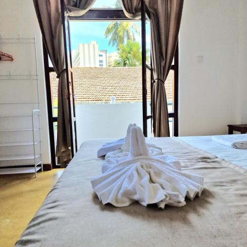a bed with a white towel on top of it at Mamma Mia Villa and Cafeteria in Unawatuna