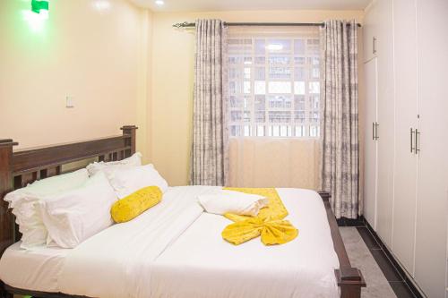 um quarto com uma cama com um laço amarelo em One Bedroom, Lake View with GYM em Nakuru