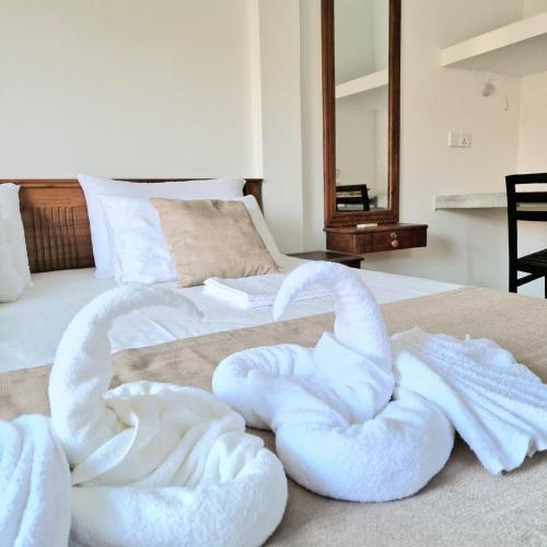 a bed with white towels on top of it at Mamma Mia Villa and Cafeteria in Unawatuna