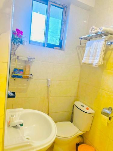 a bathroom with a white toilet and a sink at Downtown Dreamspace City - 3 bedrooms in Dar es Salaam