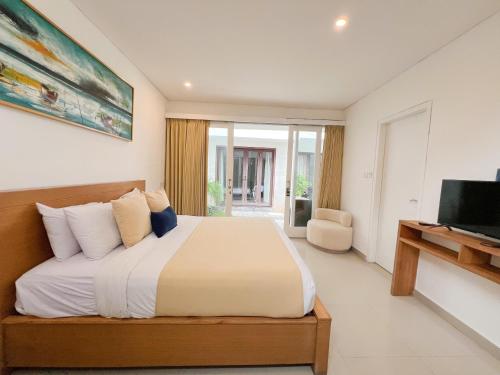a bedroom with a large bed and a television at Apple Villas & Apartments in Kerobokan
