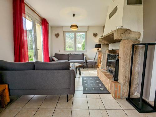 un salon avec des canapés et une cheminée dans l'établissement Gîte spacieux avec cheminée, proche nature, accessible PMR, idéal famille et motards - FR-1-589-34, à Anould