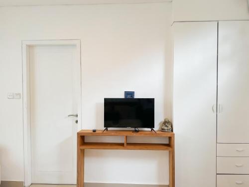 a television sitting on a wooden table in a room at Apple Villas & Apartments in Kerobokan