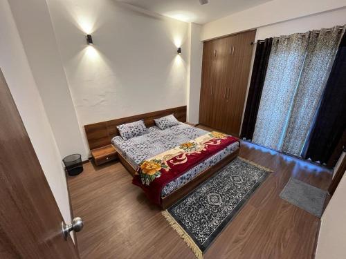 Habitación pequeña con cama y puerta en Vibe Villa, en Dehradun