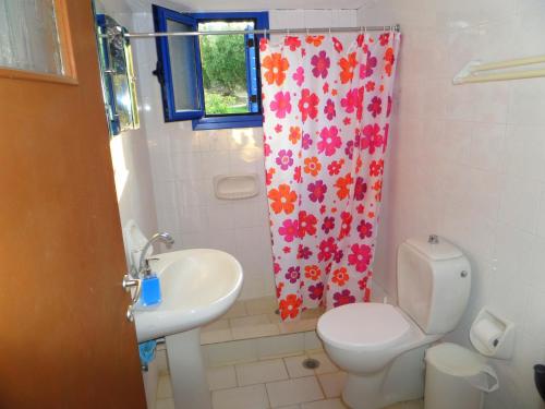 uma casa de banho com um WC, um lavatório e uma cortina de chuveiro em Tentes Holiday Homes em Vounaria