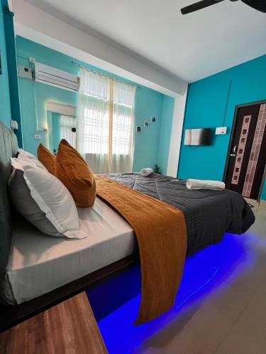 a bed in a room with blue walls at CASA FELICE BUDGET BLOCK in Tezpur