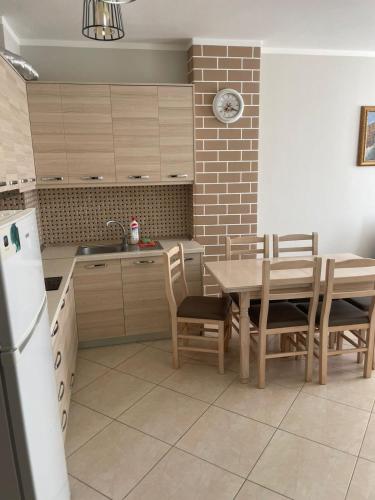a kitchen with a table and chairs and a refrigerator at Arber Apartments Deda in Shëngjin