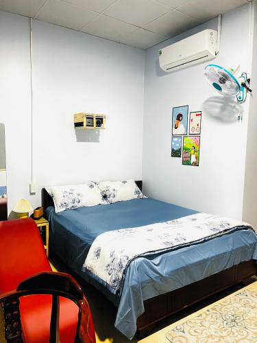 1 dormitorio con 1 cama y 1 silla roja en MOCA MOTEL en Cao Lãnh