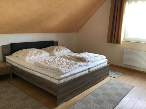 ein Bett mit weißer Bettwäsche und Kissen in einem Schlafzimmer in der Unterkunft Ferienwohnung Rosenweg in Rambin