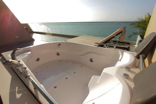 una gran bañera blanca en una habitación en Hotel Poseidon, en Manta