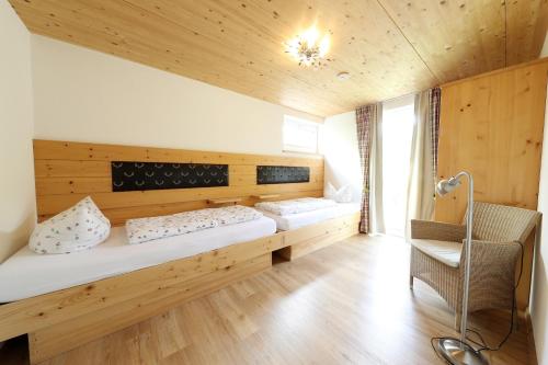 a room with two beds and a chair in it at Haus Elise in Füssen