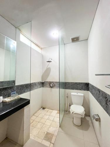 a bathroom with a toilet and a glass shower at Apple Villas & Apartments in Kerobokan