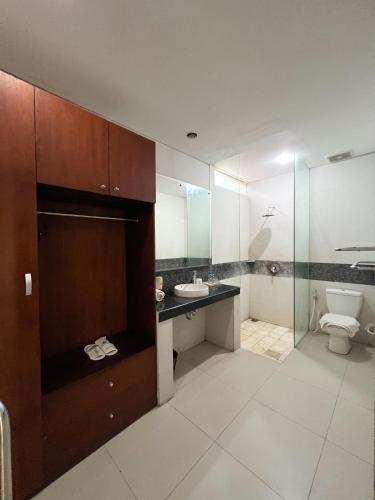 a bathroom with a toilet and a sink at Apple Villas & Apartments in Kerobokan