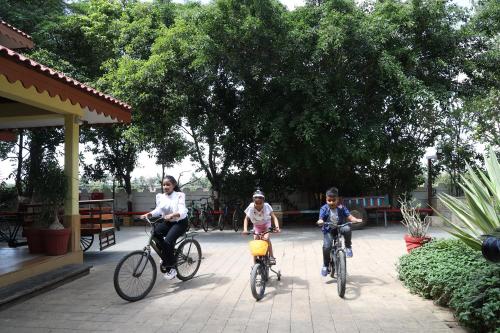 three people riding their bikes in a park at The Fern Gir Forest Resort, Sasan Gir - A Fern Crown Collection Resort in Sasan Gir