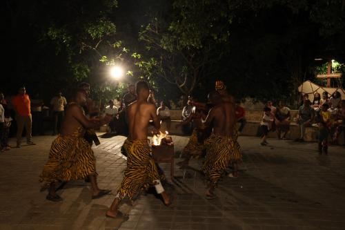 a group of men in animal costumes with a lit candle at The Fern Gir Forest Resort, Sasan Gir - A Fern Crown Collection Resort in Sasan Gir