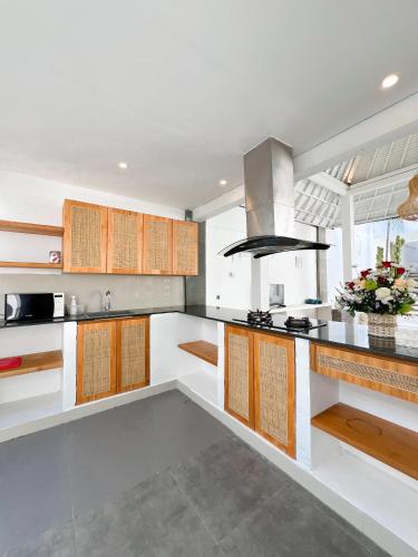 a kitchen with white counters and wooden cabinets at Apple Villas & Apartments in Kerobokan