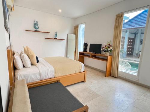 a bedroom with a bed and a tv and a window at Apple Villas & Apartments in Kerobokan