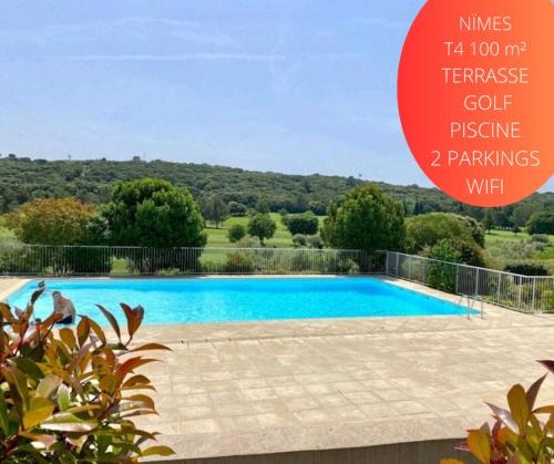 une grande piscine bleue avec un grand panneau au-dessus dans l'établissement T4 Terrasse VUE sur le GOLF, à Nîmes