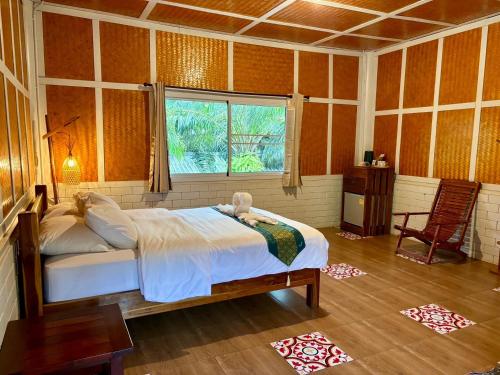 een slaapkamer met een bed in een kamer met een raam bij Golden Sword with Boat in Kanchanaburi