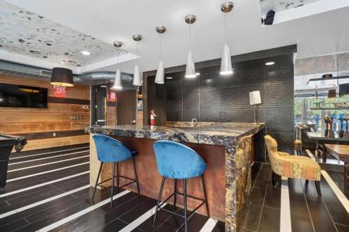 a bar in a restaurant with blue bar stools at CozySuites Mill District with pool, gym #02 in Minneapolis