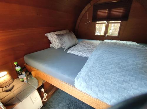 a large bed in a small room in a room at Für Alleinreisende-1 Person- Single Room- Rustikales freistehendes Mini Holzfass zum Schlafen, mit angrenzendem Badezimmer! in Leverkusen