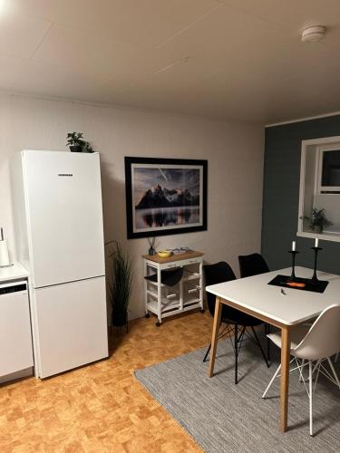 uma cozinha com um frigorífico branco e uma mesa em Leilighet i rolig gate med utsikt og gratis parkering em Tromsø
