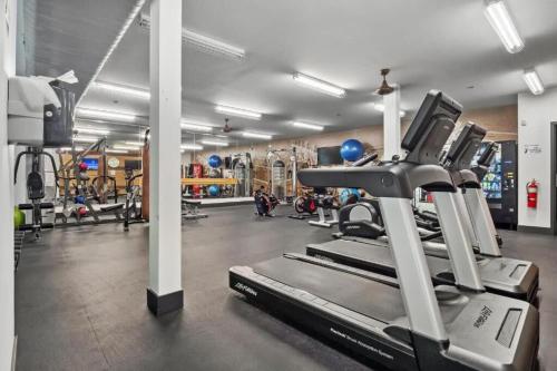 a gym with a treadmill and other equipment at CozySuites Mill District with pool, gym #08 in Minneapolis
