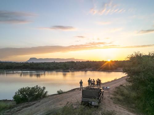 a group of people standing on a dirt road next to a river at Ukanyi Luxury Villa in Hoedspruit