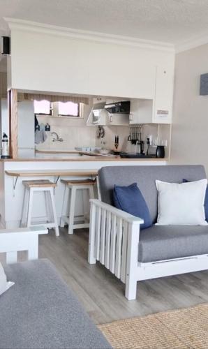 a living room with a couch and a kitchen at De Valle 37 in Mossel Bay