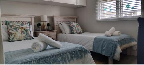 a bedroom with two twin beds and a window at De Valle 37 in Mossel Bay
