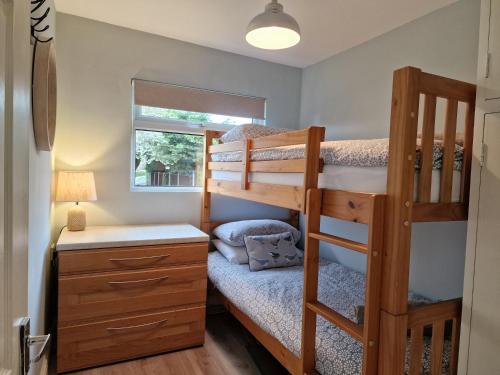 1 dormitorio con 2 literas y escritorio en 28 Broadside Holiday Chalet near Broads & Beaches en Stalham