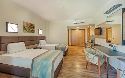 um quarto de hotel com uma cama e uma cozinha em Kimeros Park Holiday Village - Ultra All Inc. Kids Concept em Kemer
