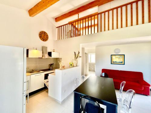 Il comprend une cuisine et un salon avec un canapé rouge. dans l'établissement Les gîtes d'Ostriconi - Villa Ogliastro, à Palasca