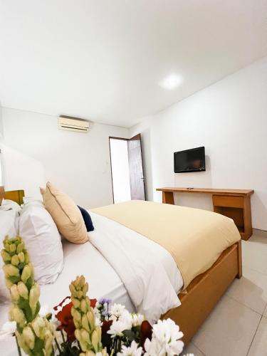 a bedroom with a bed with a tv on the wall at Apple Villas & Apartments in Kerobokan