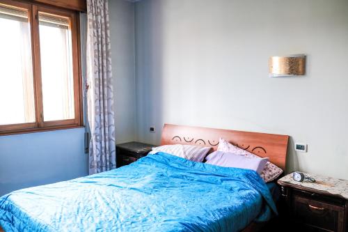 1 dormitorio con 1 cama con edredón azul y ventana en Appartamento tranquillo a 10 minuti da Padova en Sarmeola
